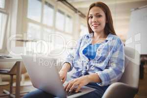 Portrait of businesswoman working on laptop in office