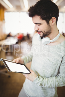 Businessman holding digital tablet in office cafeteria