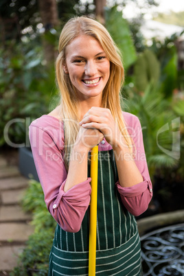 Portrait of beautiful gardener with hand tool at garden