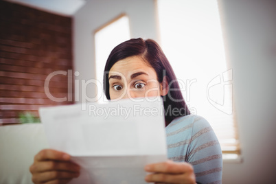 Shocked woman reading letter