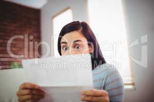 Shocked woman reading letter