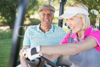 Mature couple enjoying in golf buggy