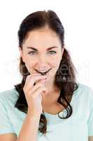 Portrait of smiling woman eating chocolate bar
