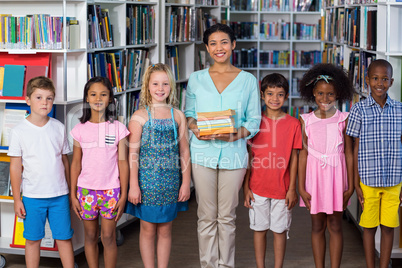 Teacher with children standing in library