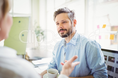Businessman discussing with colleague in creative office