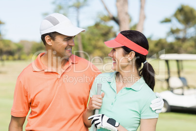 Happy golfer couple with arm around