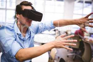 Executive gesturing while using virtual reality glasses at offic