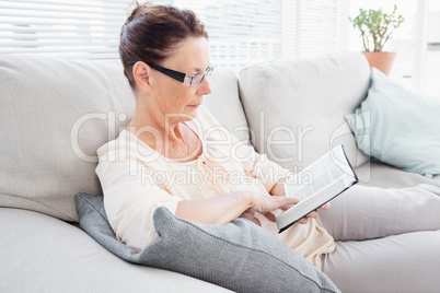 Concentrated mature woman reading book