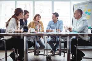 Coworkers discussing in meeting room