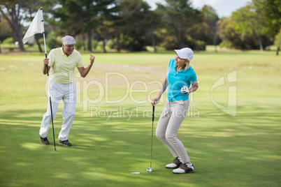 Mature golfer couple celebrating success