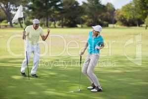 Mature golfer couple celebrating success