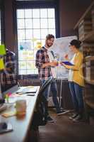 Business people standing by whiteboard against window