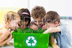 Children looking at plastic bottles in recycling box