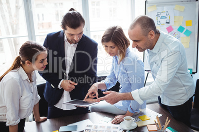 Editors using digital tablet in meeting room