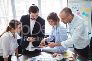Editors using digital tablet in meeting room