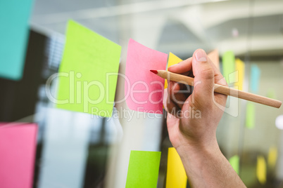 Cropped image of businessman writing on sticky notes