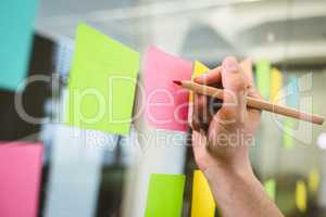 Cropped image of businessman writing on sticky notes