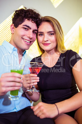 Portrait of happy couple holding cocktail glasses