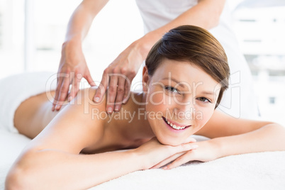 Portrait of happy woman receiving back massage