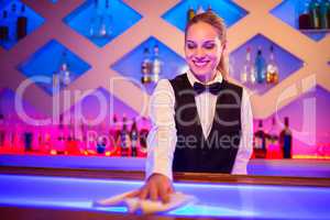 Barmaid smiling cleaning bar counter