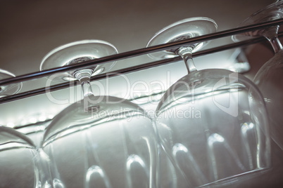 Tilt shot of wineglasses on rack at nightclub