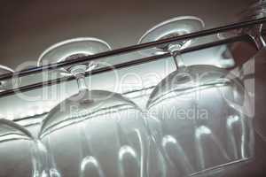 Tilt shot of wineglasses on rack at nightclub