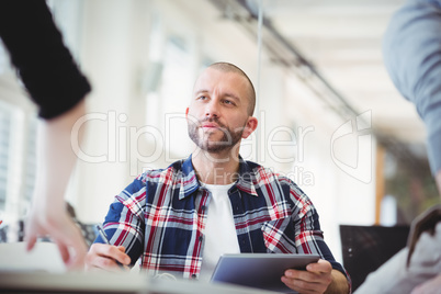 Businessmen discussing with colleagues in creative office