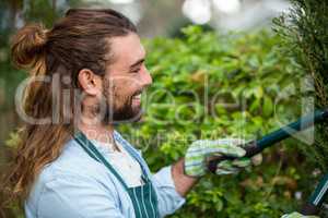 Happy gardener using hedge clippers at communicty garden