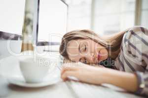 Tired businesswoman taking nap in creative office