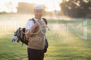 Portrait of man carrying golf bag