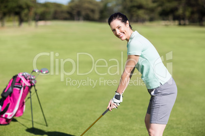 Side view of cheerful woman playing golf