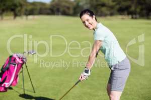 Side view of cheerful woman playing golf