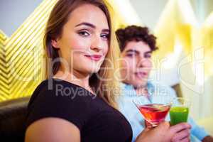 Portrait of couple holding cocktail glasses