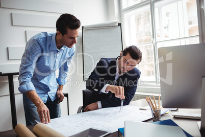 Interior designer discussing blueprint with male coworker