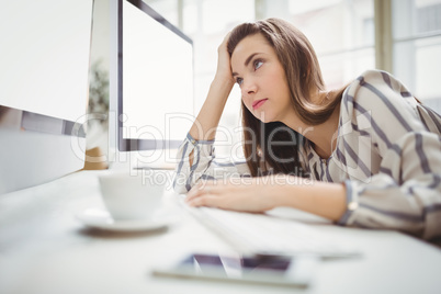 Businesswoman looking at computer in creative office