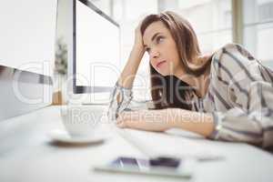 Businesswoman looking at computer in creative office