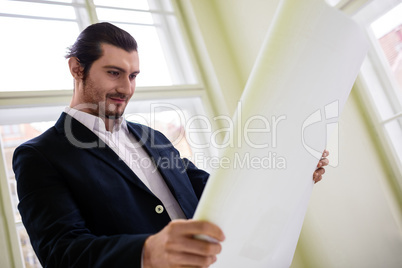 Low angle view of architect holding blueprint