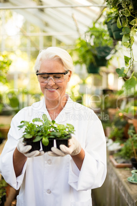 Happy female scientist holding plants
