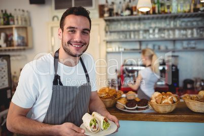 Portrait of happy barista with fresh rolls