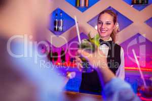 Young barmaid serving drink to male costumer