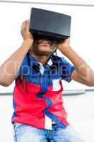 Front view of boy using virtual reality headset in classroom