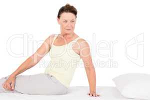 Confident mature woman exercising on bed