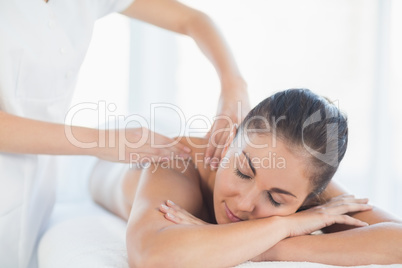 Relaxed woman receiving back massage