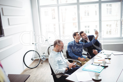 Business people taking selfie in meeting room