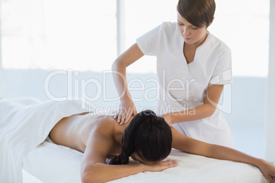 Masseuse giving massage to woman