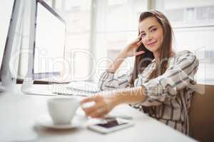 Portrait of businesswoman holding coffee cup in creative offic