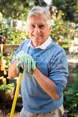 Portrait of happy gardener with tool at garden