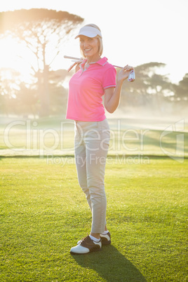 Woman golfer posing with her golf club