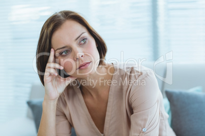 Thoughtful woman sitting at home