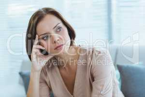 Thoughtful woman sitting at home